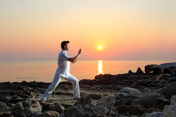 Handsome man practicing thai chi on the beach — Stock Photo, Image