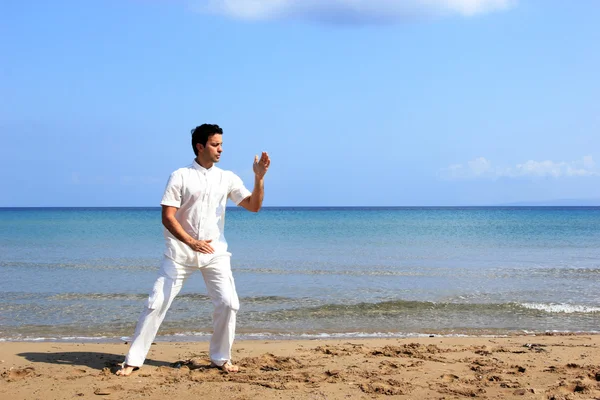 Bell'uomo che pratica il thai chi sulla spiaggia — Foto Stock