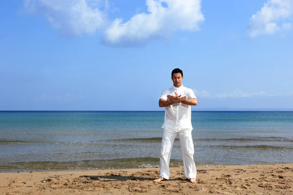 Красивый мужчина, практикующий тай-чи на пляже. — стоковое фото