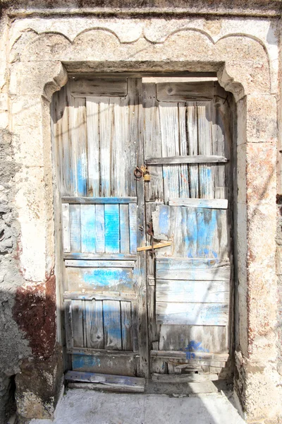 Eine sehr abgewetzte und ramponierte alte blaue Tür — Stockfoto