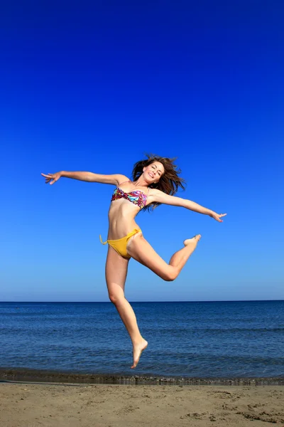 Menina bonita pulando graciosamente na praia — Fotografia de Stock