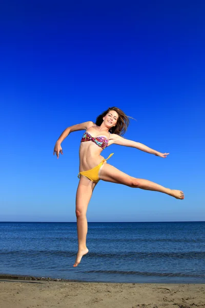 Krásná dívka, která skočila ladně na pláži — Stock fotografie