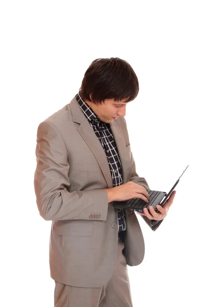 Mladý obchodní muž stojící s notebookem — Stock fotografie