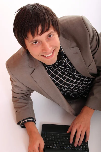 ノート パソコンで立っている若いビジネス男 — ストック写真