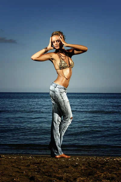 Fashion model in jeans by the sea — Stock Photo, Image