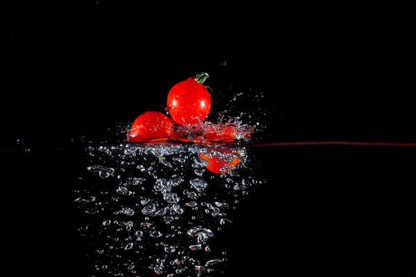 Splashing tomatoes into a water — Stock Photo, Image