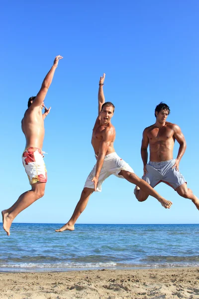 Drei junge Männer am Strand — Stockfoto