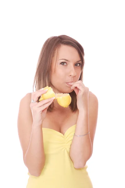 Молода жінка їсть кислий лимон — стокове фото