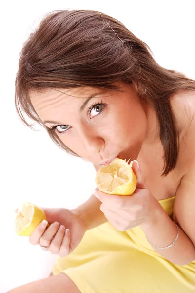 Young woman eating sour lemon Stock Photo