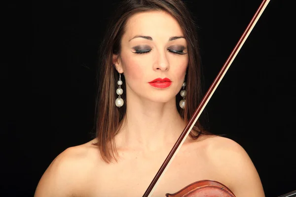 Mujer sosteniendo un violín sobre un fondo negro . — Foto de Stock