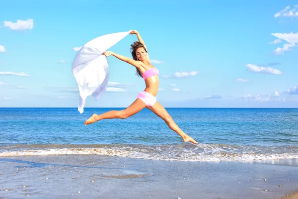 Vrouw springen op het strand — Stockfoto