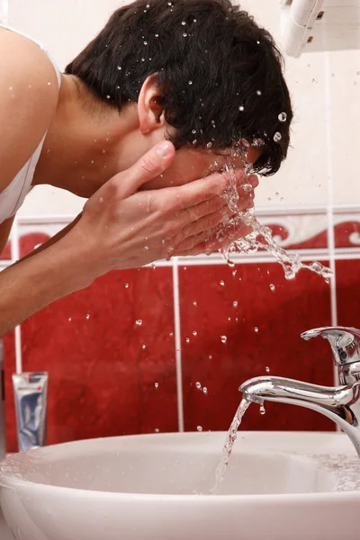 Junger Mann wäscht Gesicht — Stockfoto