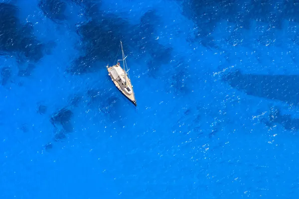 Derin mavi sularda bir tekne — Stok fotoğraf