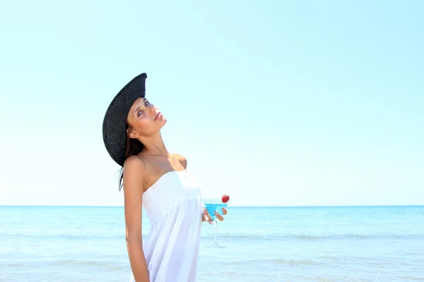 Красивая девушка на пляже с коктейлем — стоковое фото