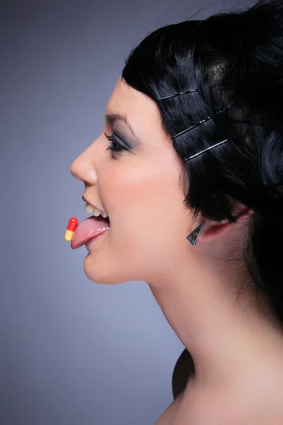 Молодая женщина ест таблетки — стоковое фото