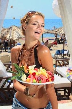 Young smiling woman with fruits salad clipart