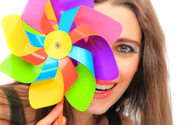 Beautiful young woman holding a multicolored pinwheel — Stock Photo, Image