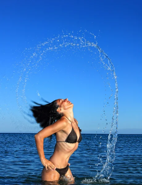 Aranyos lány a strandon, fröccsen ki a vízből — Stock Fotó