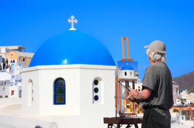 Painter artist paints a picture of Santorini clipart