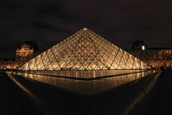 PARÍS - 8 de enero de 2012: Primer plano de la pirámide del Louvre brilló al atardecer en París, Francia . — Foto de Stock