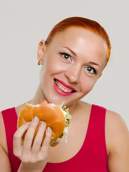 ハンバーガーを持つ女性の笑みを浮かべてください。 — ストック写真