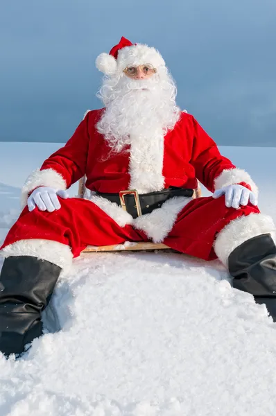 Санта сидит на шезлонге в снегу — стоковое фото