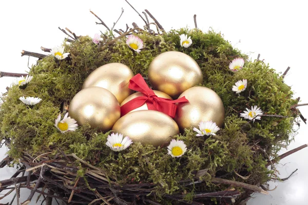 Пасхальный шоколад и золотые яйца в птичьем гнезде — стоковое фото