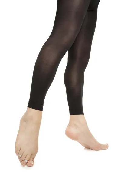 Woman legs wearing footless black tights over white background — Stock Photo, Image