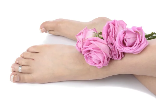 Piedi femminili e fiori su sfondo bianco — Foto Stock