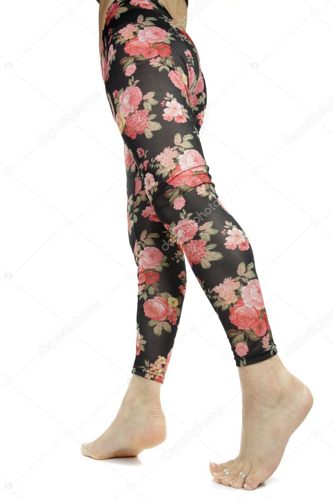 Female legs wearing floral leggings over white background