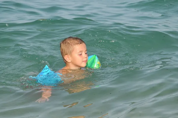 Menino no mar aprendendo a nadar — Fotografia de Stock