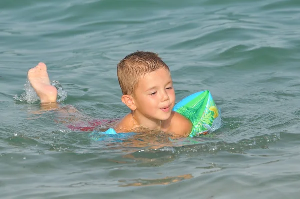 Niño en el mar aprendiendo a nadar — Foto de Stock