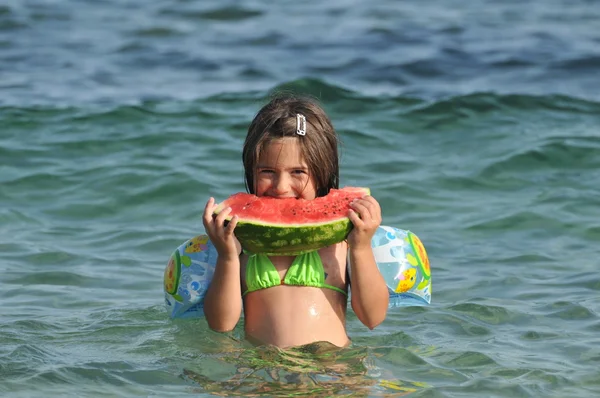 Menina comendo melancia na praia — Fotografia de Stock