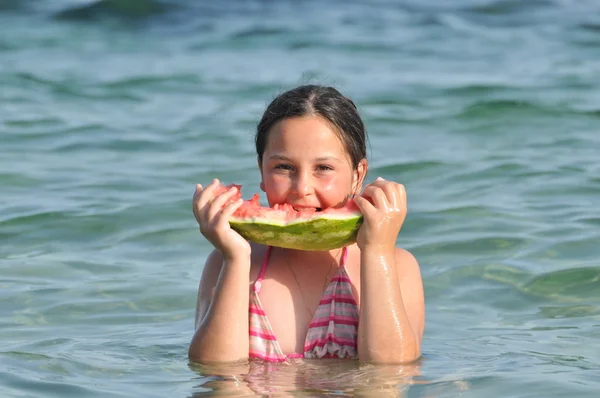 Chica comiendo sandía en la orilla del mar — Foto de Stock