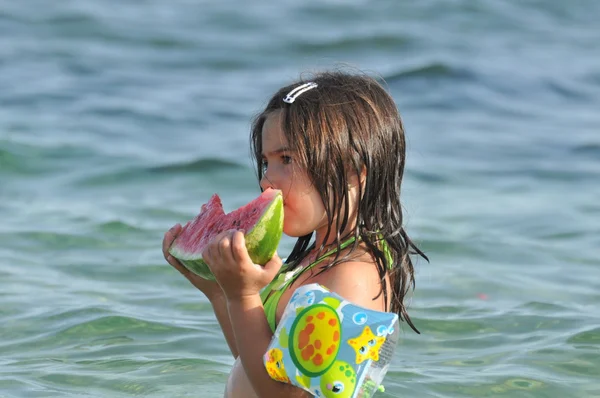 Girl eating watermelon on seashore — Stock Photo, Image