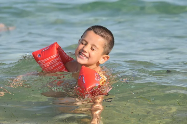 Мальчик на море учится плавать — стоковое фото