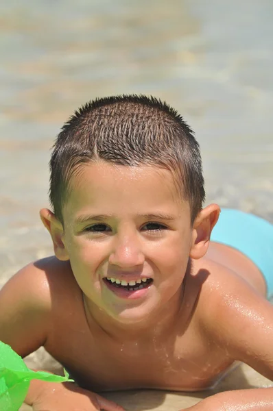 Glad ung pojke på stranden — Stockfoto