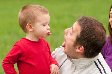 Father and son having fun outdoor on beautiful spring day clipart