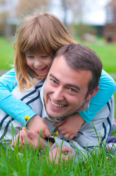 Padre e figlia si divertono nell'erba nella bella giornata primaverile — Foto Stock