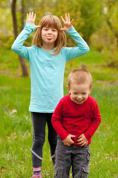 Brother and sister posing outside on beautiful spring day — Stock Photo, Image