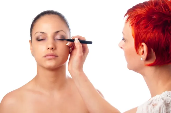 Makeupartist tillämpa makeup på vända mot av vacker flicka — Stockfoto