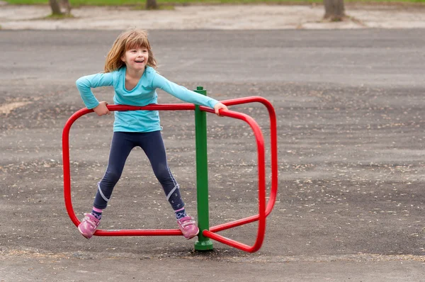Carina bambina che gioca nel parco giochi nella bella giornata primaverile — Foto Stock