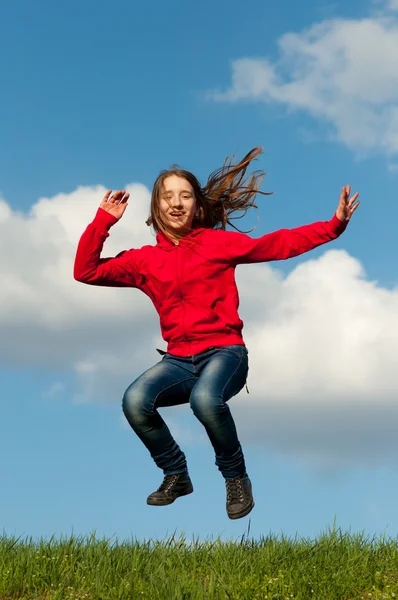 Sevimli genç kız sevinçle güneşli bir bahar gününde atlama — Stok fotoğraf