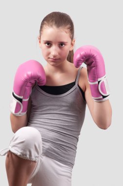 Portrait of pretty kick boxing girl with pink gloves exercising clipart