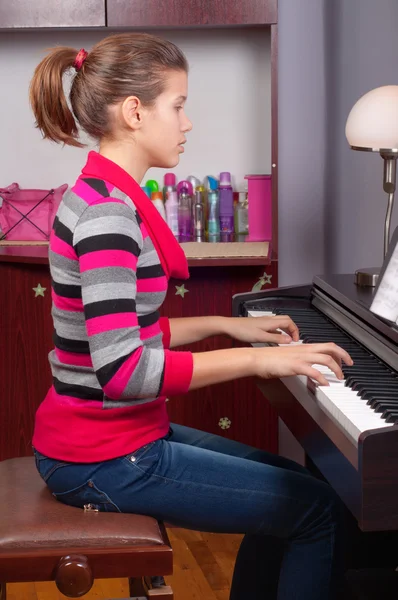 Menina adolescente bonita tocando no piano em seu quarto — Fotografia de Stock