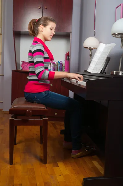 Muito sorridente adolescente tocando piano em seu quarto — Fotografia de Stock