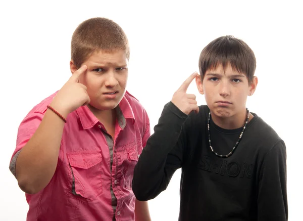 Two serious teenage boys showing on their heads — Zdjęcie stockowe