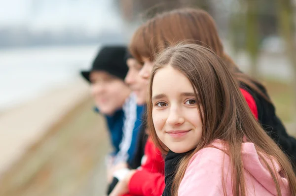 Docela usměvavá dívka venkovní s přáteli v pozadí — Stock fotografie