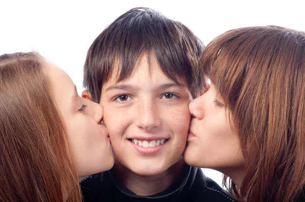 Two pretty girls kissing smiling boy in the cheeks — Stock Photo, Image