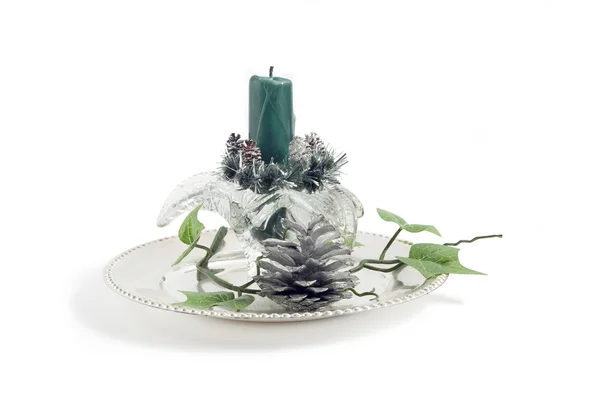 stock image Glass candlestick with green candle on the silver plate